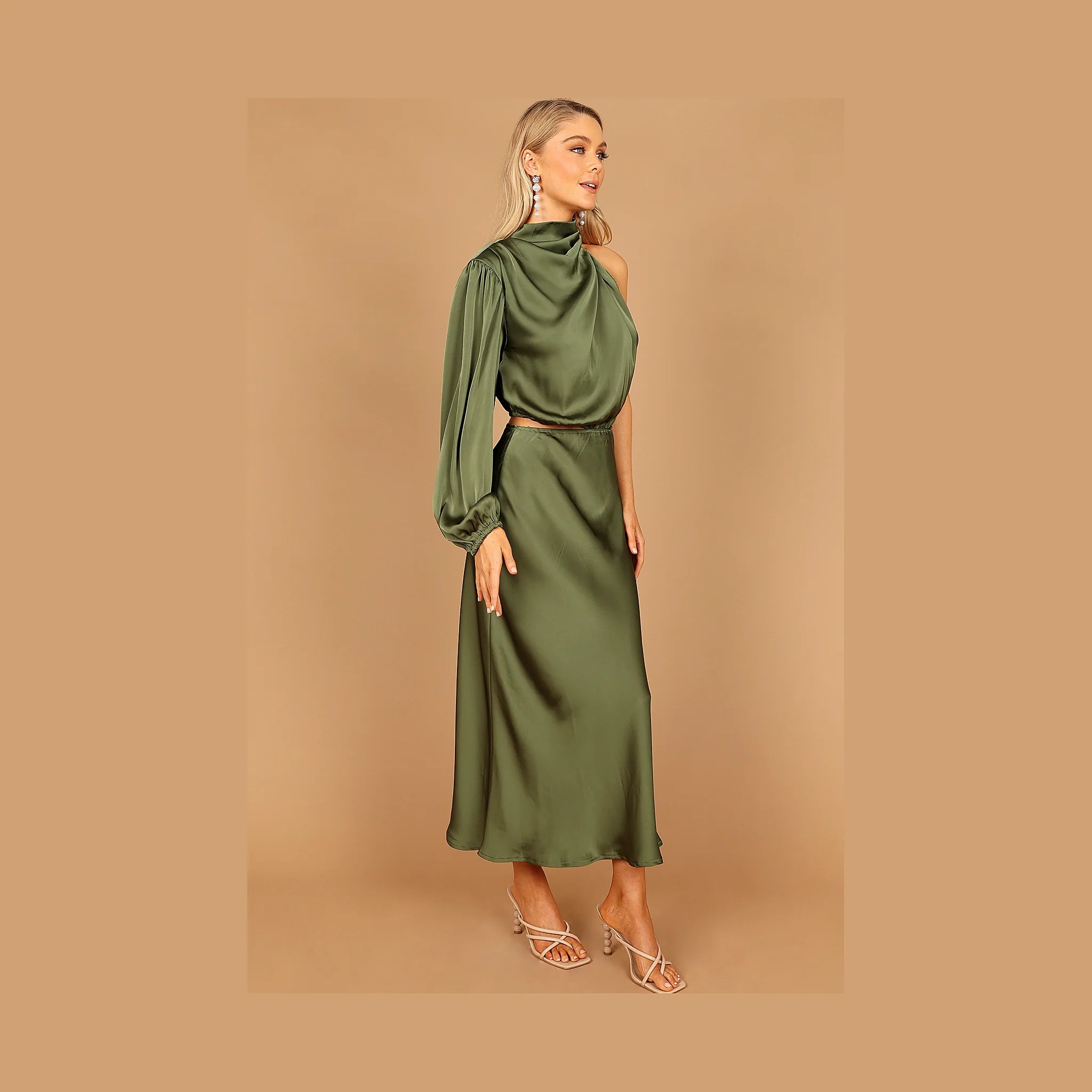 One-sleeved green dress with gathered pleated detail at the neckline
