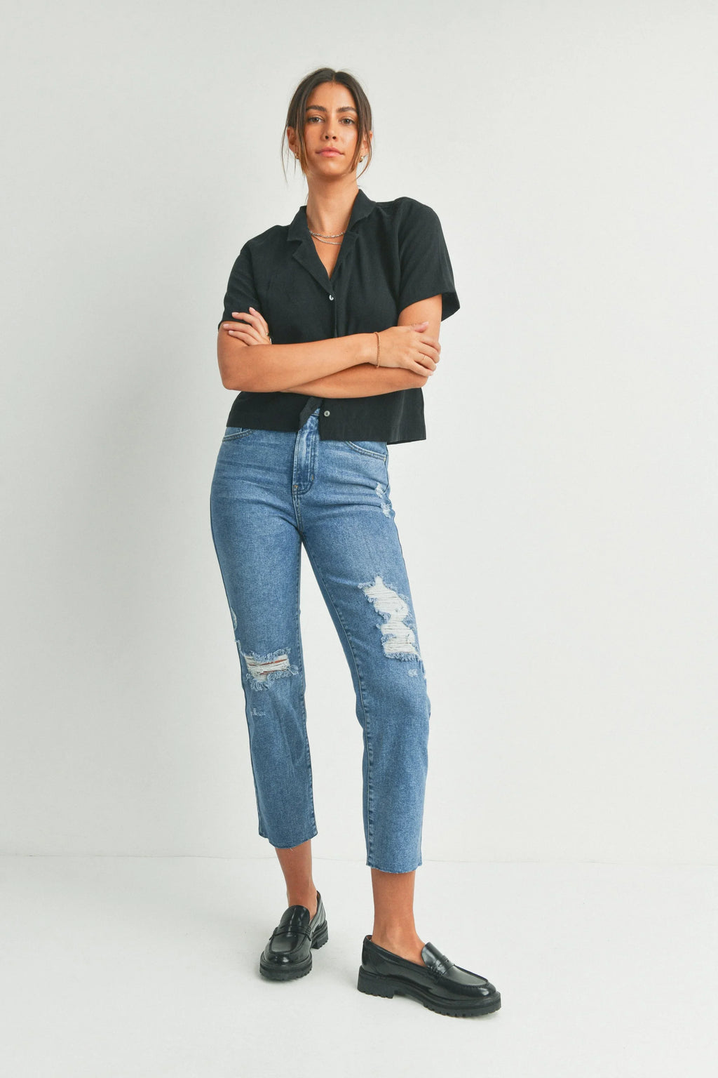 Ripped knee detailing on a black straight leg jean