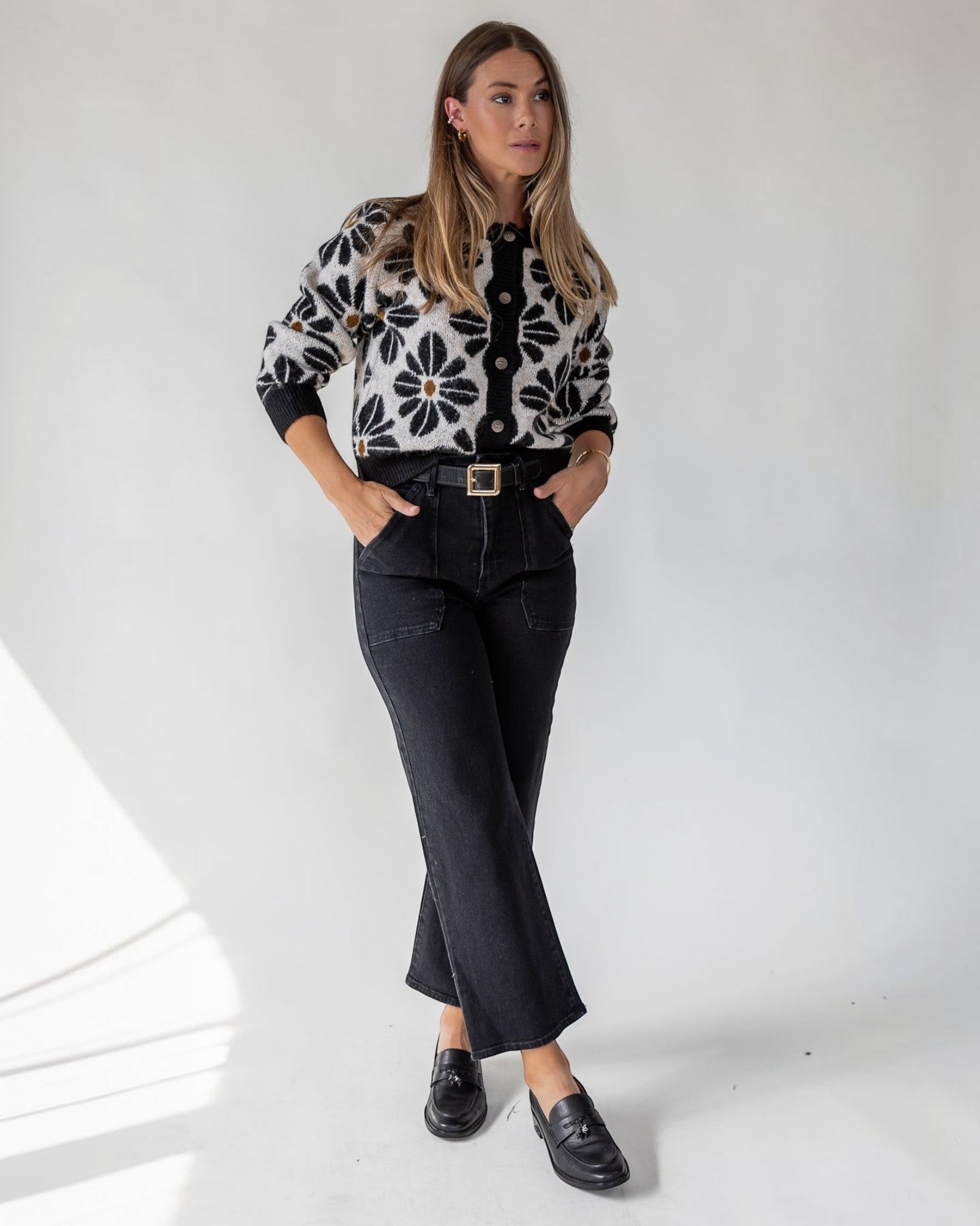 Contrast rib trim framing the edges of a black floral cardigan