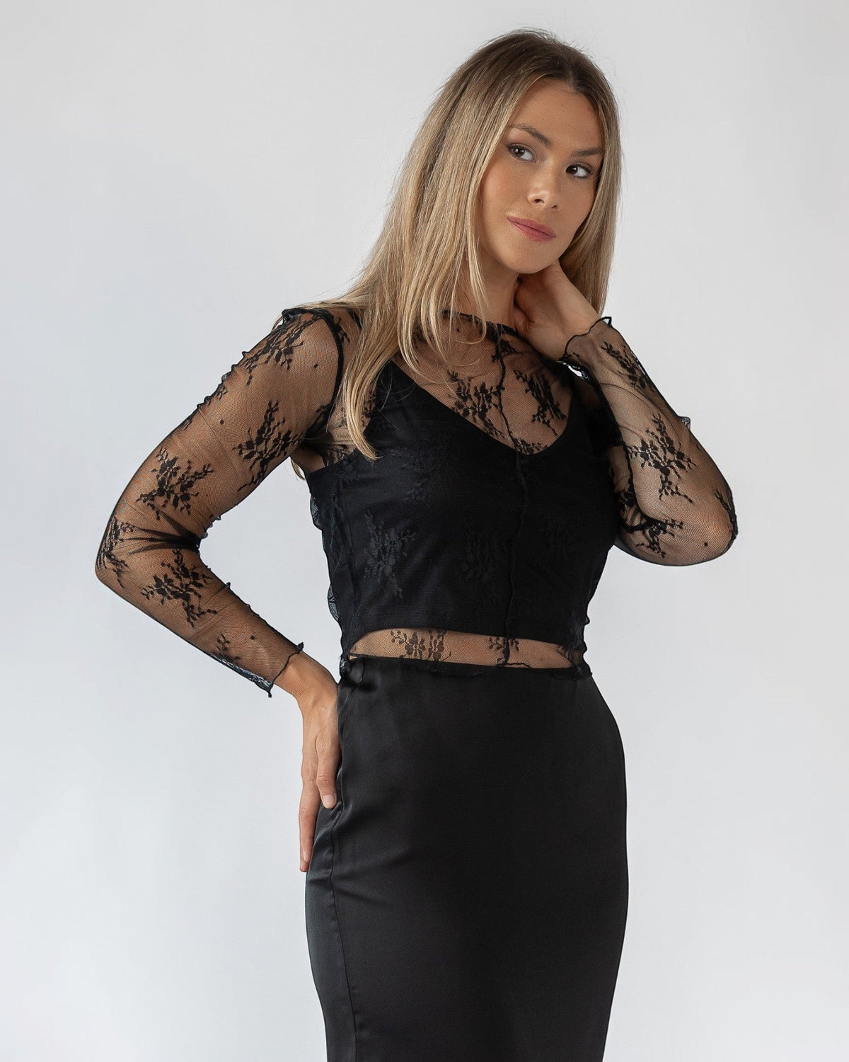 Feminine floral lace worked across a cropped black cami