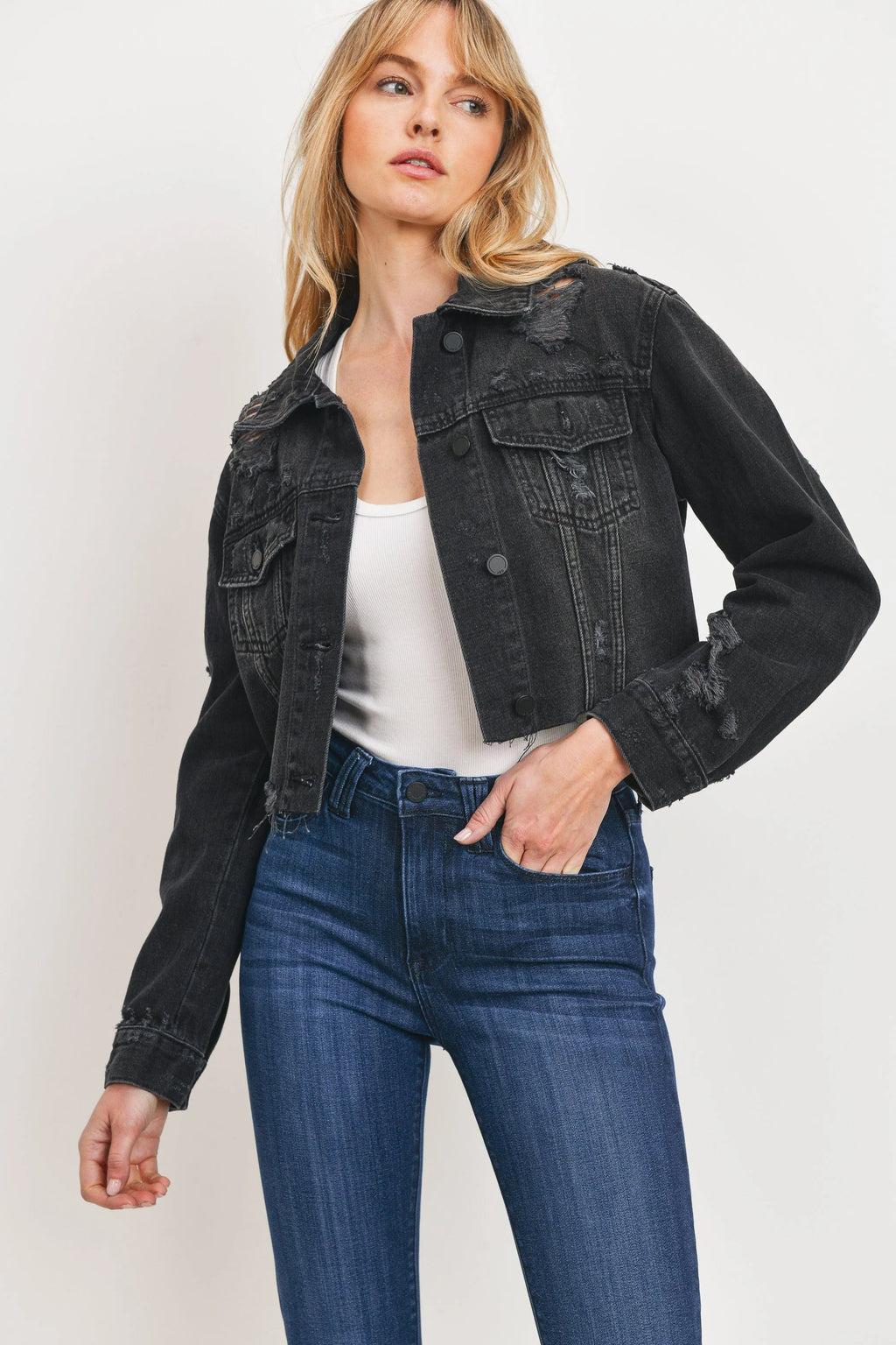 Distressing worked into the sleeves and pockets of a black jacket