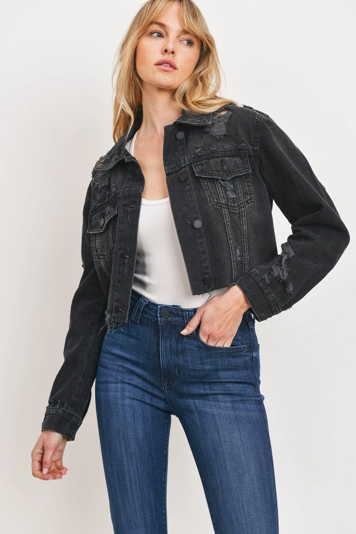 Distressing worked into the sleeves and pockets of a black jacket