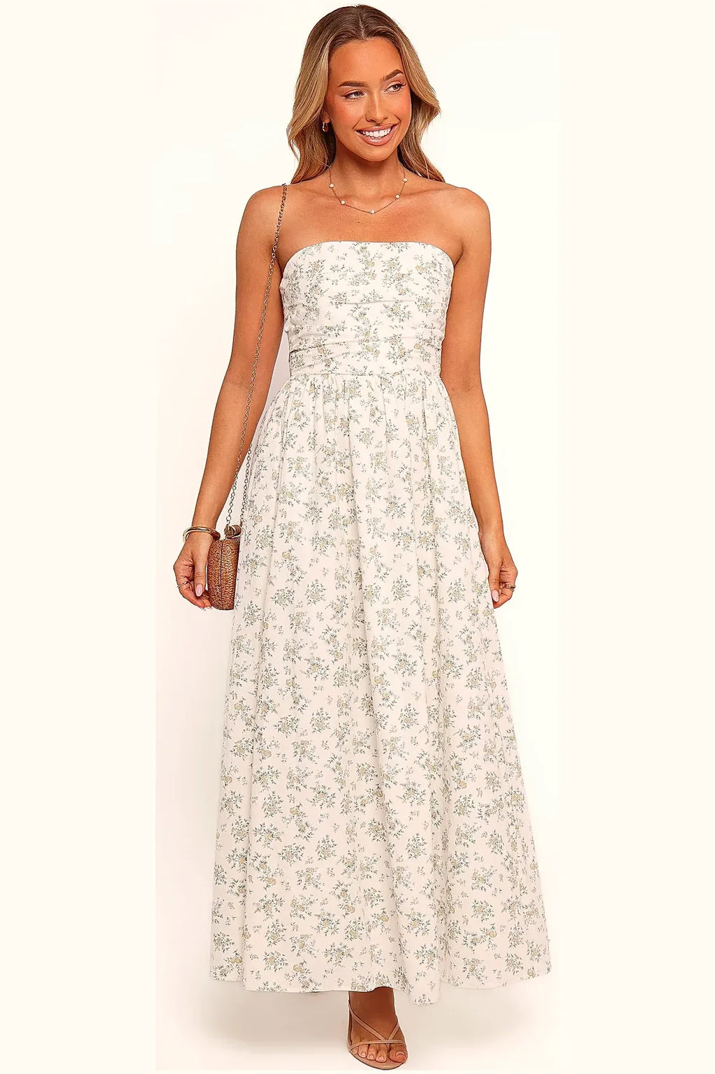 Side view of a long green floral strapless dress with pleats