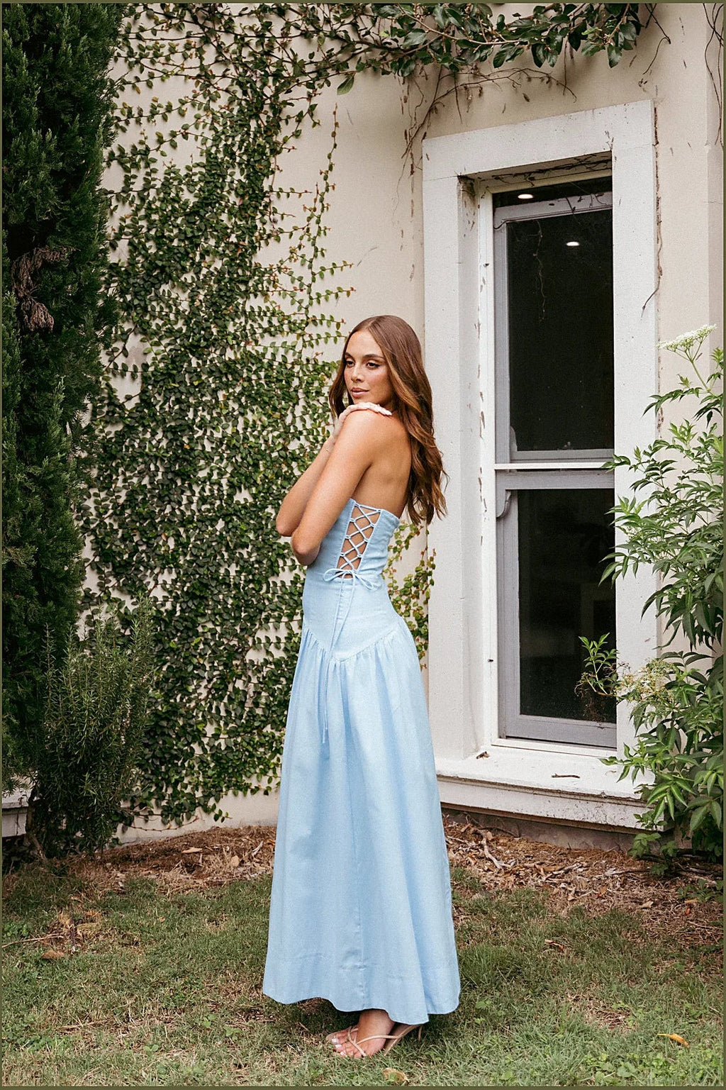 Long blue strapless dress seen from the side showing the tie