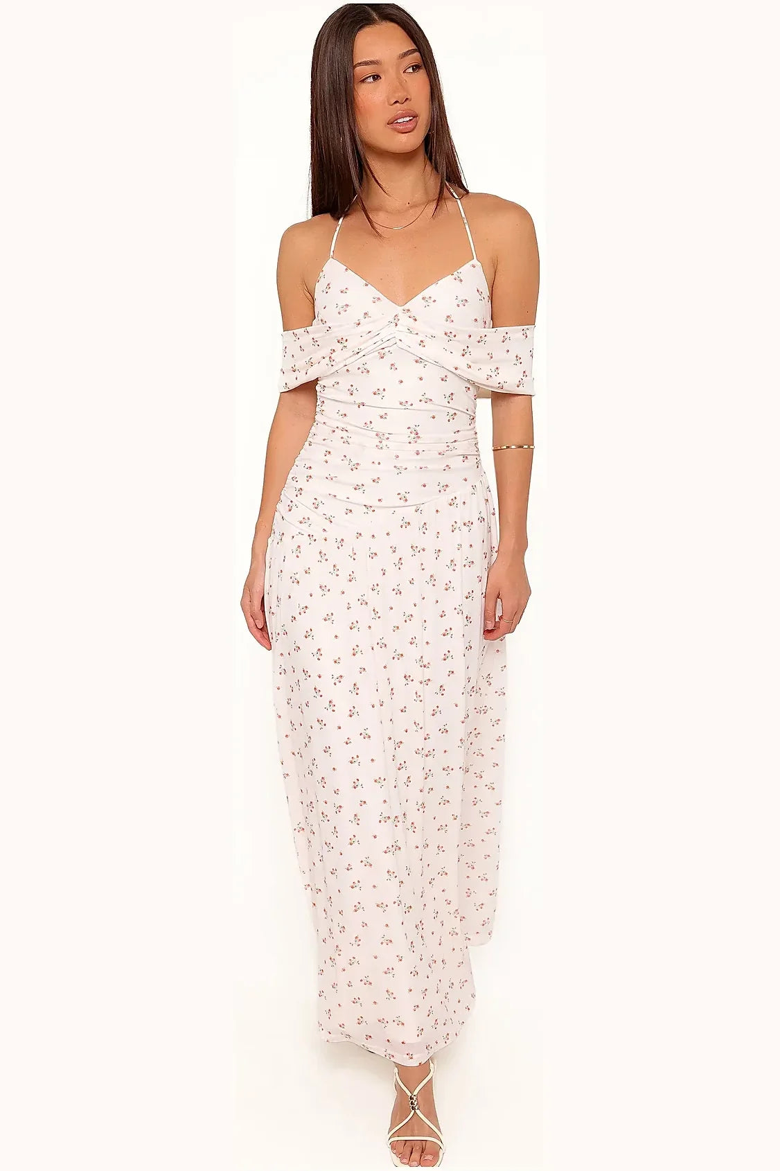 Side angle of a long white ditsy floral halter dress