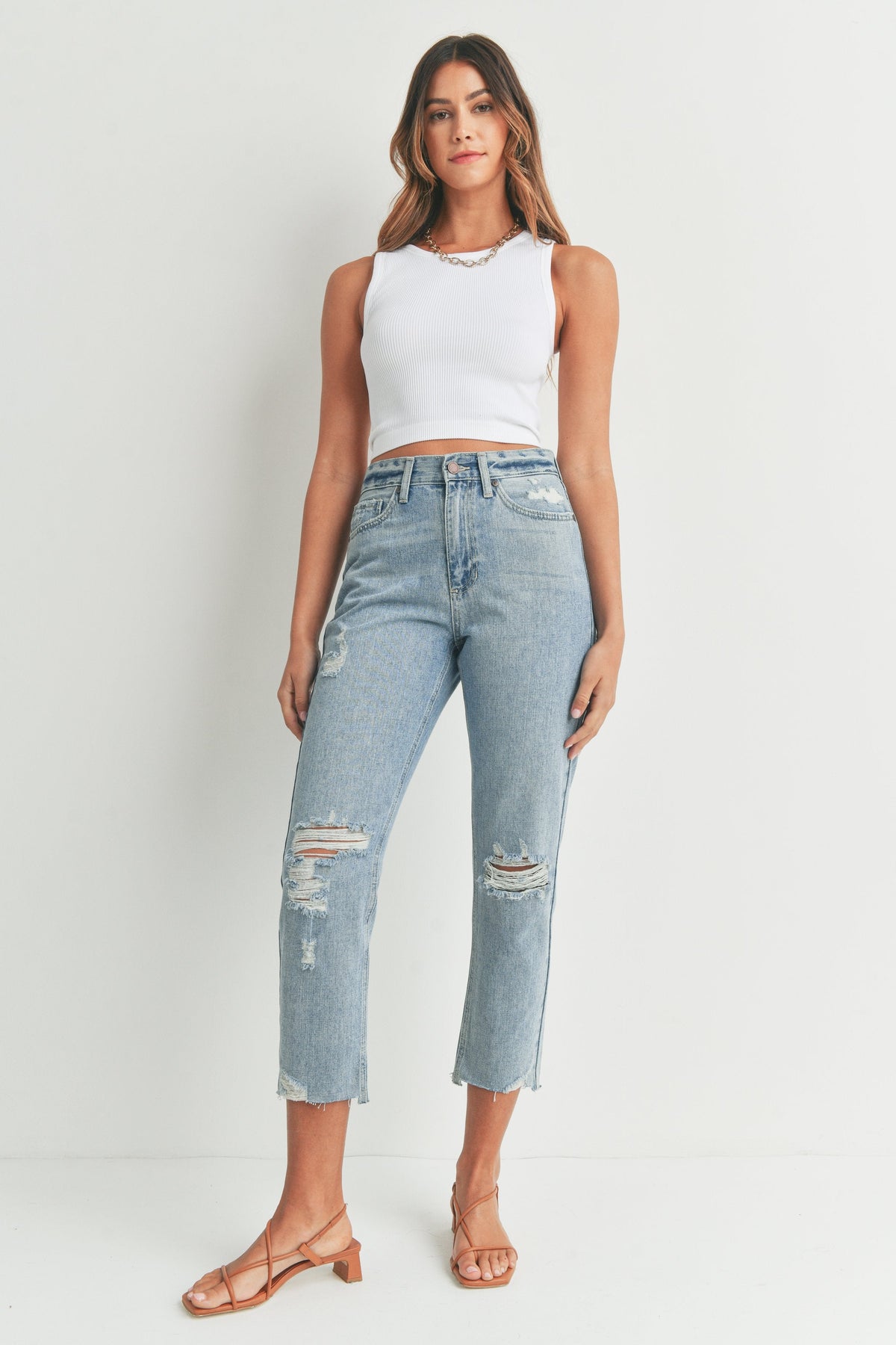 Raw unfinished hem at the ankle of a cropped jean