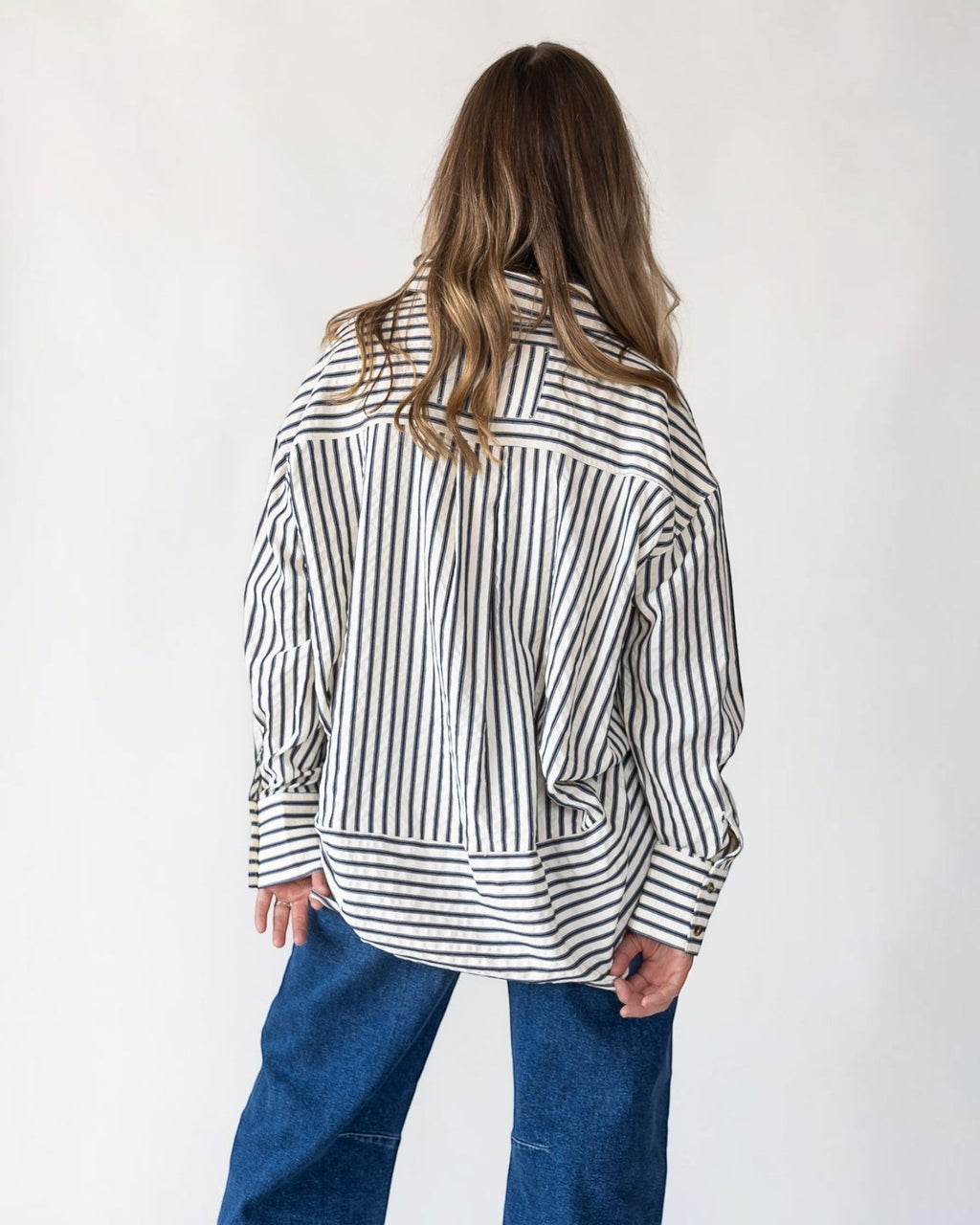 Tortoise button closure running down a navy striped shirt