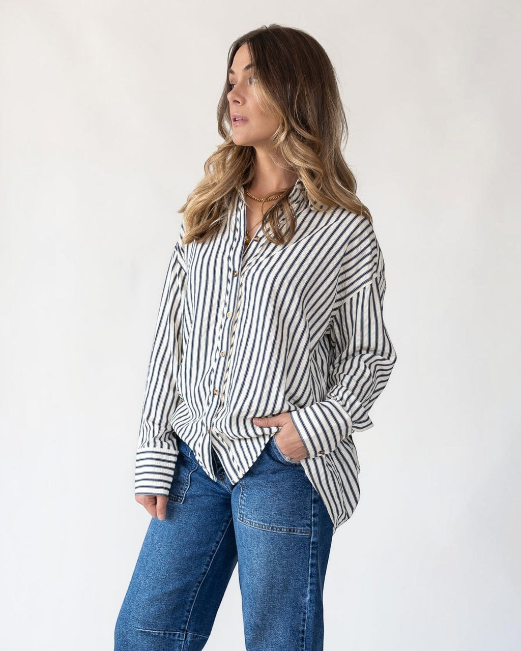 Pleated drape hem released at the back of an oversized shirt