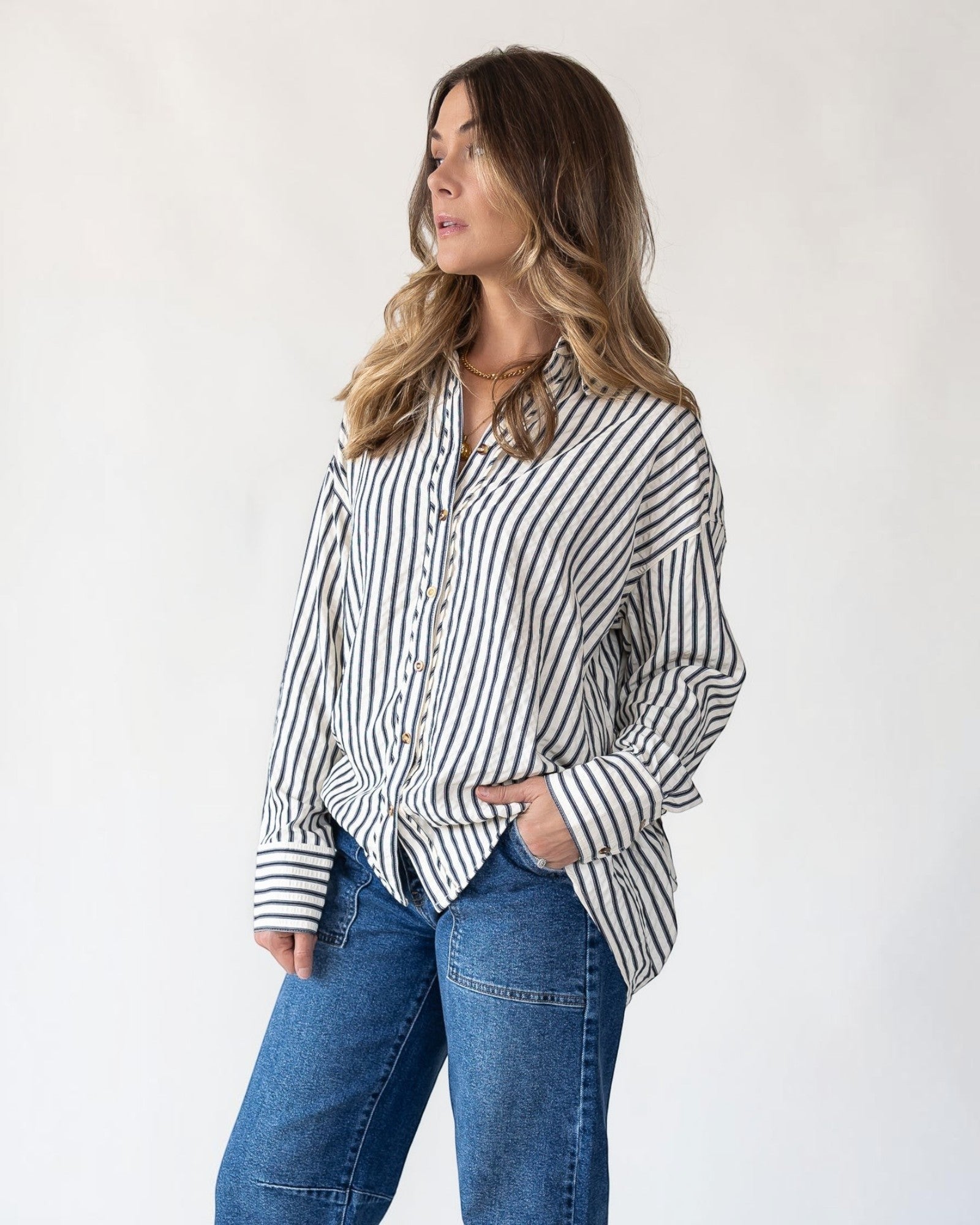 Pleated drape hem released at the back of an oversized shirt