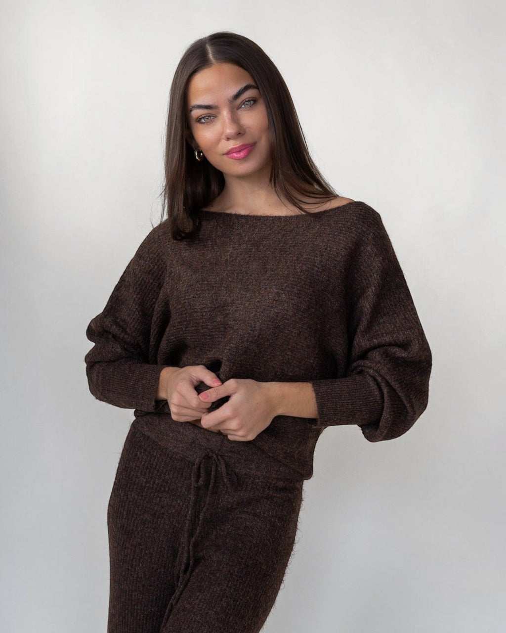 Wide boat neckline running shoulder to shoulder on a brown rib-knit sweater