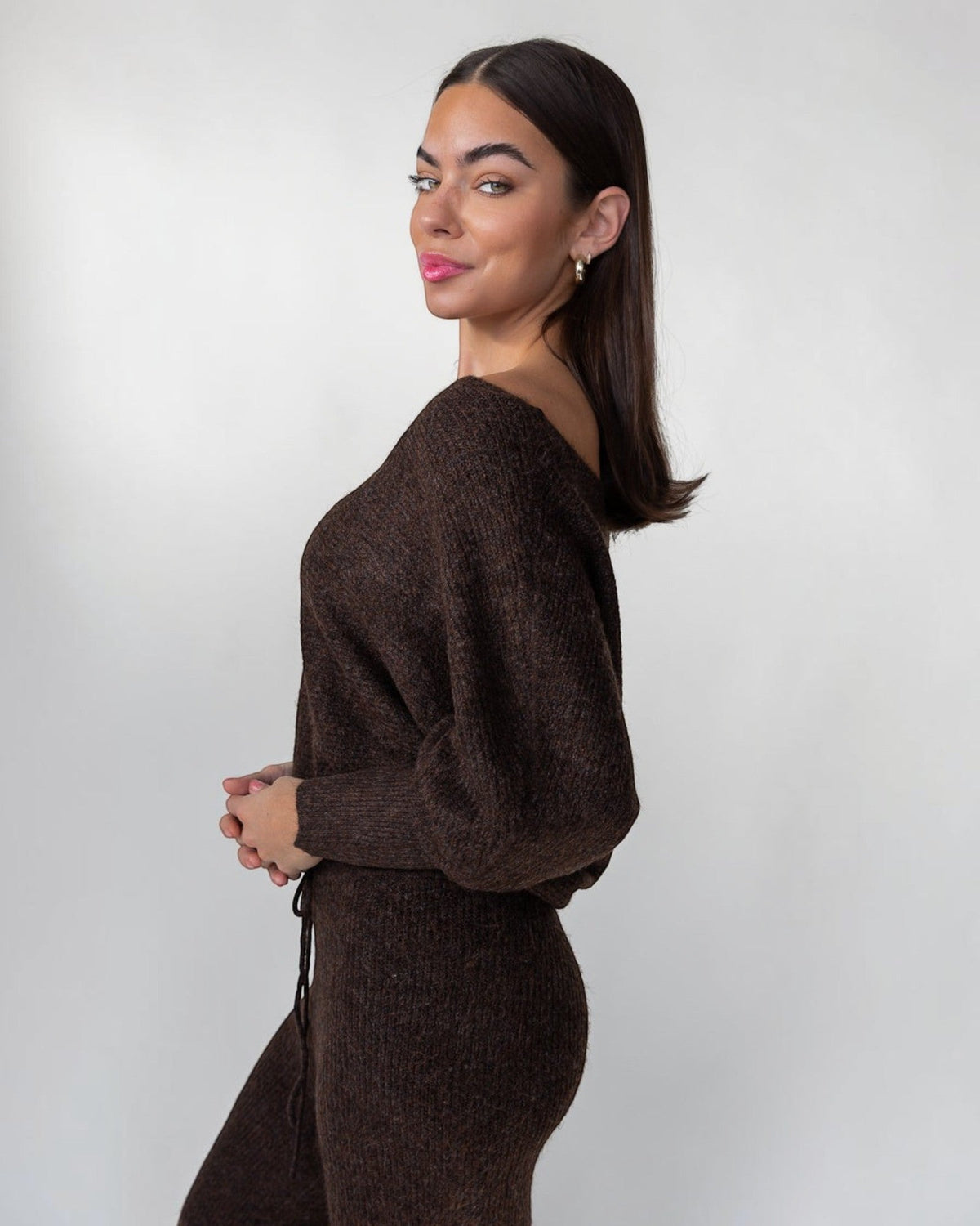 Blouson sleeves gathering into a ribbed cuff on a plush brown knit