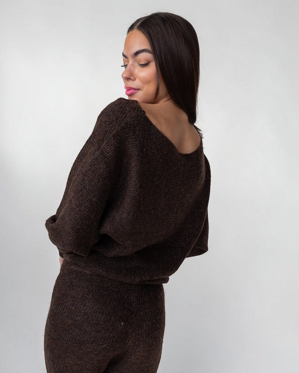 Ribbed hem holding the shape of a soft brown boat neck sweater