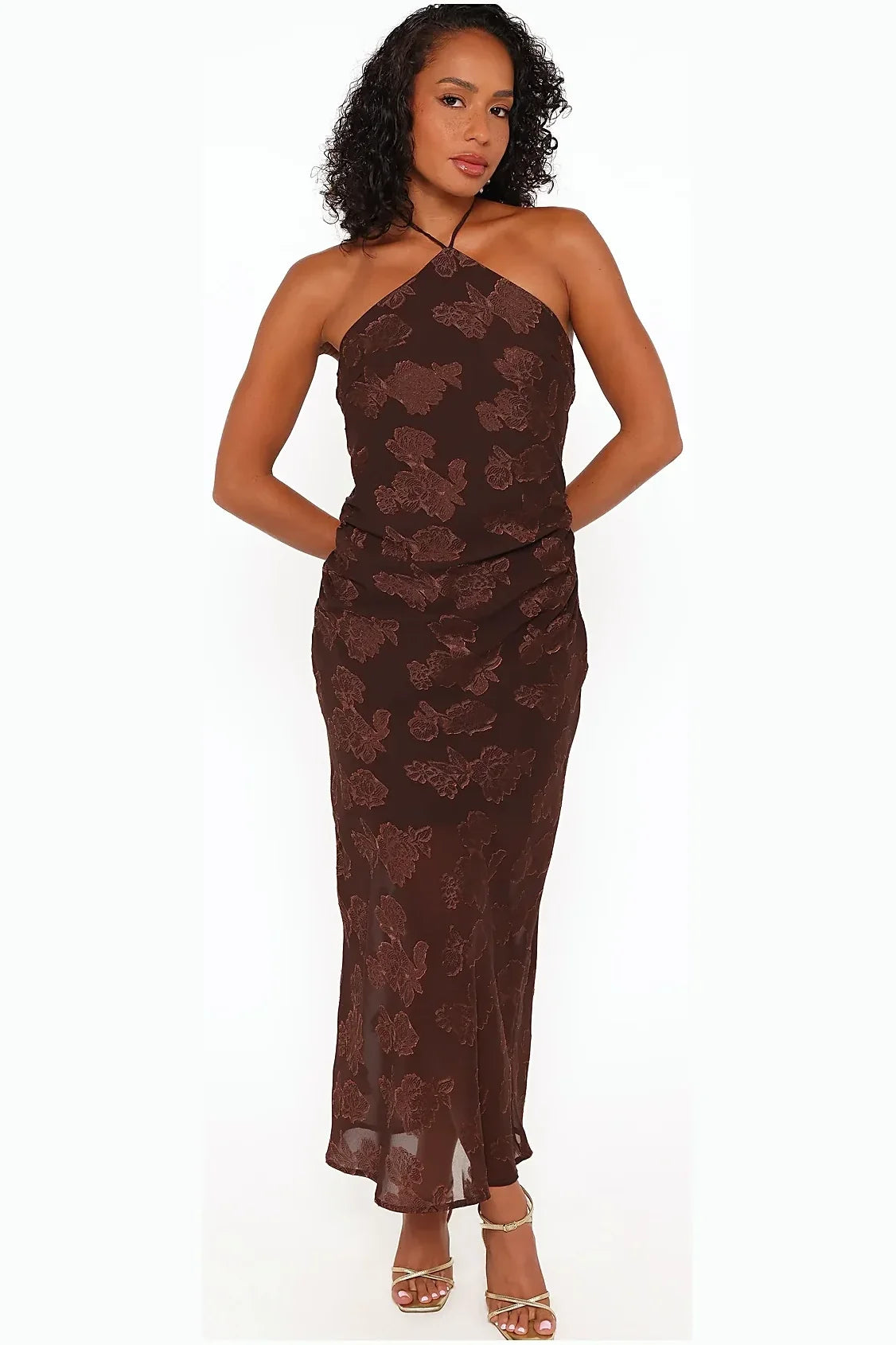 Long brown halterneck dress seen from the side