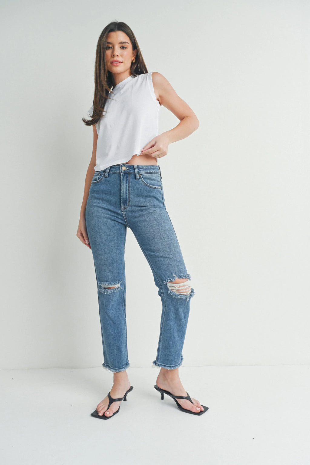 Frayed slits set at each knee of a slim straight jean