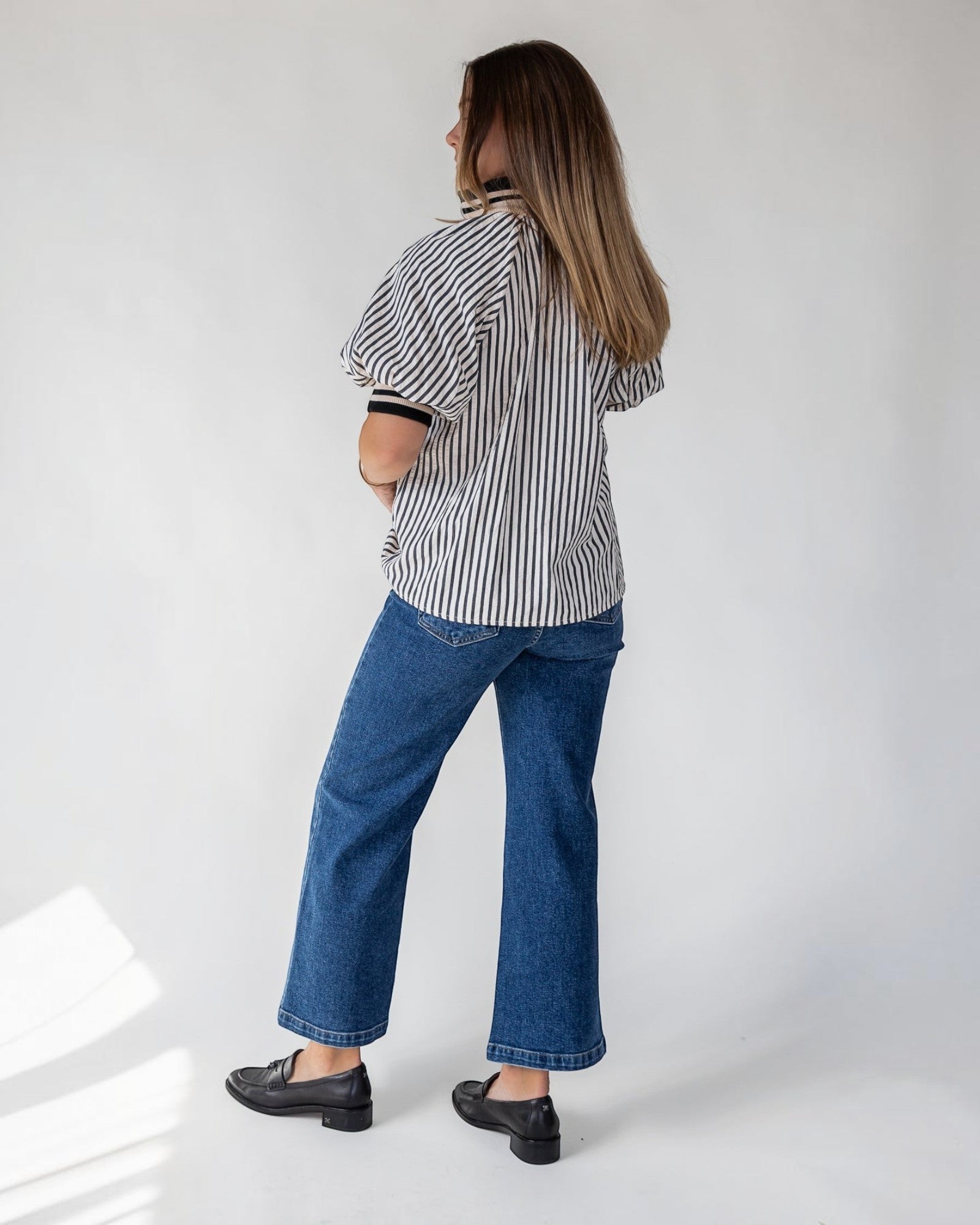 Short puff sleeves adding shape at the shoulder of a black striped top