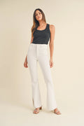 Subtle slit opening at the hem of a white flare jean